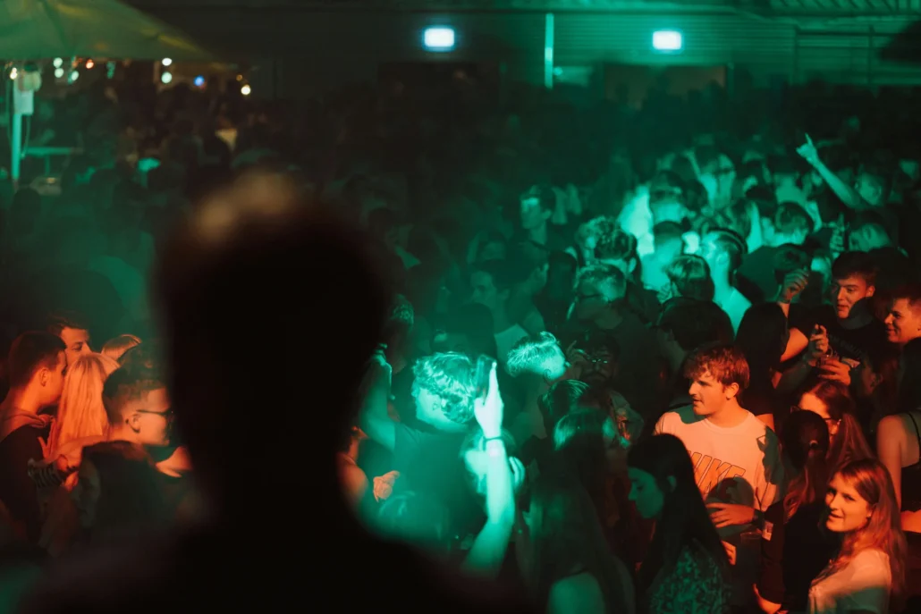 Rush Poppers Guide: Review, Scents & Where to Buy 3 Crowd at a concert under party lights — Rush Poppers guide